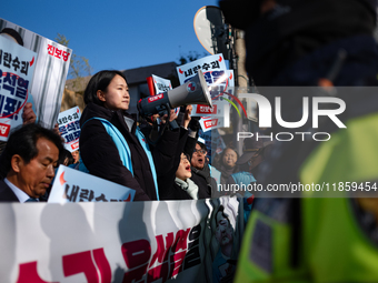 Protesters hold portraits of President Yoon Suk-yeol with the phrase ''Arrest Yoon Suk-yeol, the Rebellion Leader'' written on them as they...