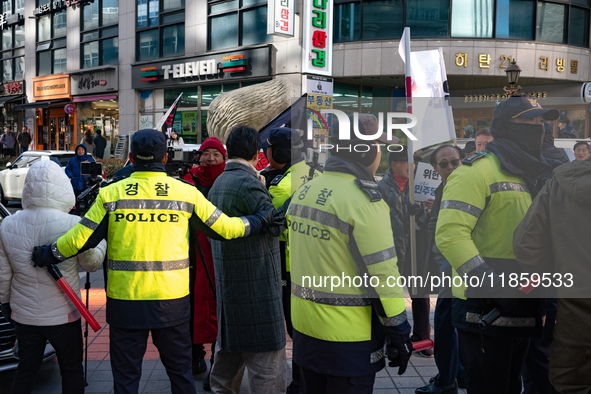 Police mediate between supporters of President Yoon Suk-yeol and those calling for his impeachment to prevent conflicts in front of the Peop...