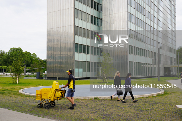 In Düsseldorf, Germany, on May 23, 2022, a Deutsche Post postman wearing the company’s signature yellow and black uniform delivers mail with...