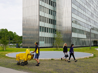 In Düsseldorf, Germany, on May 23, 2022, a Deutsche Post postman wearing the company’s signature yellow and black uniform delivers mail with...