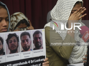 Family members wipe his tears at a media conference in Colombo, Sri Lanka, on December 12, 2024. Four Sri Lankan nationals are arrested by I...