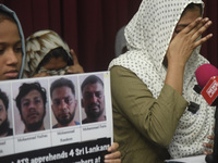 Family members wipe his tears at a media conference in Colombo, Sri Lanka, on December 12, 2024. Four Sri Lankan nationals are arrested by I...