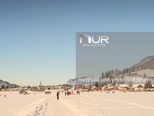 People walk through the snowy landscape near Bavarian Oberstdorf in Bavaria, Swabia, Oberallgau, Germany, on January 20, 2024. Oberstdorf is...