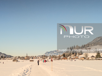 People walk through the snowy landscape near Bavarian Oberstdorf in Bavaria, Swabia, Oberallgau, Germany, on January 20, 2024. Oberstdorf is...