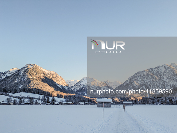 A man walks through the snowy landscape near Bavarian Oberstdorf in Bavaria, Swabia, Oberallgau, Germany, on January 20, 2024. Oberstdorf is...