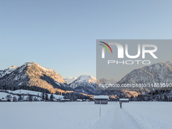 A man walks through the snowy landscape near Bavarian Oberstdorf in Bavaria, Swabia, Oberallgau, Germany, on January 20, 2024. Oberstdorf is...