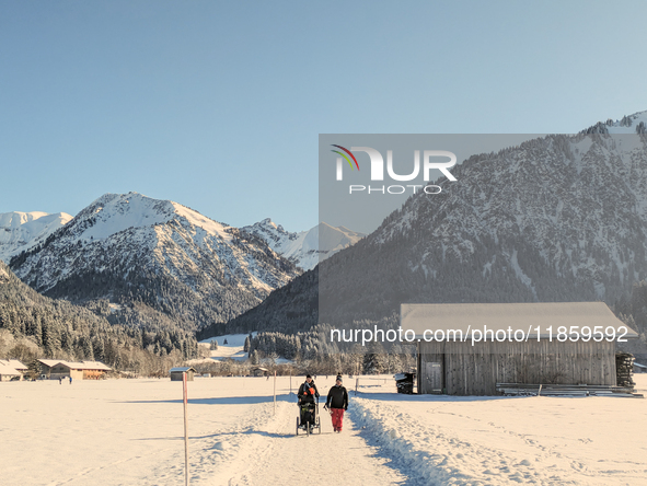 A family walks through the snowy landscape near Bavarian Oberstdorf in Bavaria, Swabia, Oberallgau, Germany, on January 20, 2024. Oberstdorf...