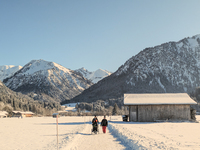 A family walks through the snowy landscape near Bavarian Oberstdorf in Bavaria, Swabia, Oberallgau, Germany, on January 20, 2024. Oberstdorf...