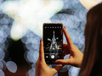 A tourist takes a photo of the large Christmas tree in Cava de'Tirreni, Salerno, Italy, on December 11, 2024. (