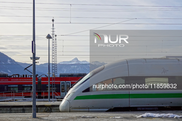 On November 24, 2024, in Garmisch-Partenkirchen, Bavaria, Germany, an ICE train with its sleek design stands next to a vibrant red Regional...