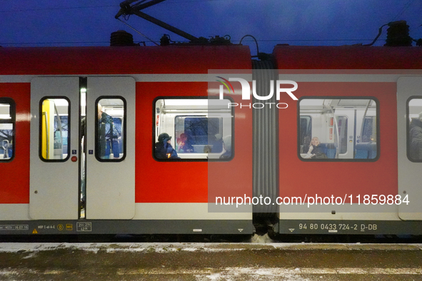 Passengers are inside a red Deutsche Bahn S-Bahn train at the Gauting suburban station in Bavaria, Germany, on November 22, 2024.