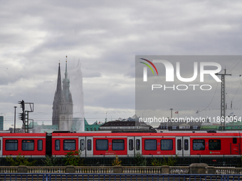 A red S-Bahn Hamburg train traverses a rail line with the city’s iconic skyline in the background in Hamburg, Germany, on August 28, 2022....