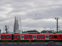 A red S-Bahn Hamburg train traverses a rail line with the city’s iconic skyline in the background in Hamburg, Germany, on August 28, 2022....