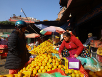 People purchase oranges from a local market in Kathmandu, Nepal, on December 12, 2024. Nepali fruit markets are flooded with oranges as the...