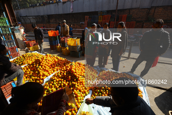 People purchase oranges from a local market in Kathmandu, Nepal, on December 12, 2024. Nepali fruit markets are flooded with oranges as the...