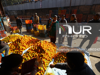 People purchase oranges from a local market in Kathmandu, Nepal, on December 12, 2024. Nepali fruit markets are flooded with oranges as the...