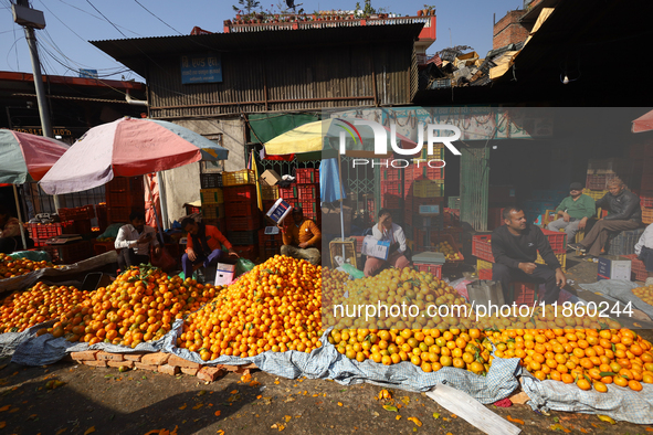 Nepali vendors wait for customers at a local market in Kathmandu, Nepal, on December 12, 2024. Nepali fruit markets are flooded with oranges...