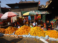 Nepali vendors wait for customers at a local market in Kathmandu, Nepal, on December 12, 2024. Nepali fruit markets are flooded with oranges...