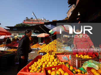 People purchase oranges from a local market in Kathmandu, Nepal, on December 12, 2024. Nepali fruit markets are flooded with oranges as the...