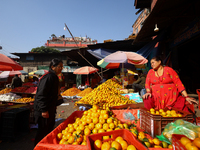 People purchase oranges from a local market in Kathmandu, Nepal, on December 12, 2024. Nepali fruit markets are flooded with oranges as the...