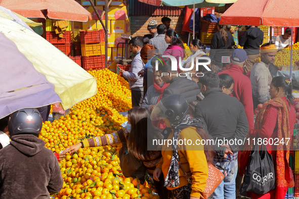 People purchase oranges from a local market in Kathmandu, Nepal, on December 12, 2024. Nepali fruit markets are flooded with oranges as the...