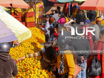 People purchase oranges from a local market in Kathmandu, Nepal, on December 12, 2024. Nepali fruit markets are flooded with oranges as the...