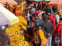 People purchase oranges from a local market in Kathmandu, Nepal, on December 12, 2024. Nepali fruit markets are flooded with oranges as the...