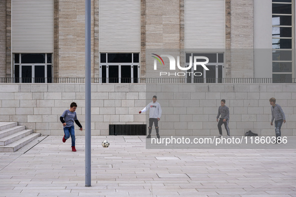 A group of four boys plays soccer on a forecourt of a modern building in Lido, Venice Lagoon, Italy, on November 13, 2021. 