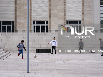 A group of four boys plays soccer on a forecourt of a modern building in Lido, Venice Lagoon, Italy, on November 13, 2021. (