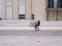 A boy cycles on a forecourt of a modern building in Lido, Venice Lagoon, Italy, on November 13, 2021. (