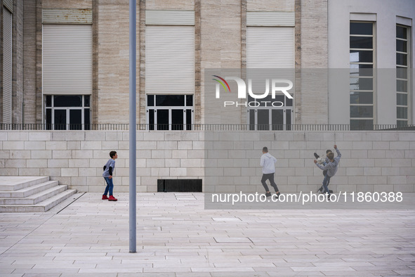 A group of four boys plays soccer on a forecourt of a modern building in Lido, Venice Lagoon, Italy, on November 13, 2021. 