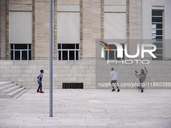 A group of four boys plays soccer on a forecourt of a modern building in Lido, Venice Lagoon, Italy, on November 13, 2021. (