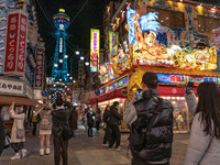 Tourists take photos in Shinsekai with Tsutenkaku tower in sight in Osaka, Japan, on December 12, 2024. Shinsekai, which means 'New World' i...