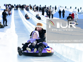 Tourists play at the Manzhouli ''Ice and Snow Nursery Rhyme'' theme park in Hulunbuir, Inner Mongolia, China, on December 12, 2024. (