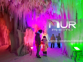 Tourists play at the Manzhouli ''Ice and Snow Nursery Rhyme'' theme park in Hulunbuir, Inner Mongolia, China, on December 12, 2024. (