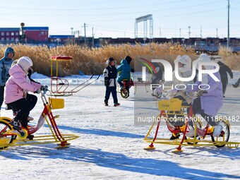 Tourists play at the Manzhouli ''Ice and Snow Nursery Rhyme'' theme park in Hulunbuir, Inner Mongolia, China, on December 12, 2024. (