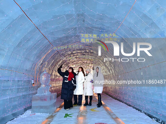 Tourists play at the Manzhouli ''Ice and Snow Nursery Rhyme'' theme park in Hulunbuir, Inner Mongolia, China, on December 12, 2024. (