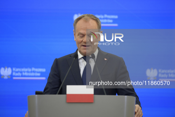 Polish Prime Minister Donald Tusk looks down as he speaks during a press conference with French President Emmanuel Macron after talks in War...