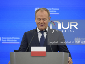 Polish Prime Minister Donald Tusk looks down as he speaks during a press conference with French President Emmanuel Macron after talks in War...