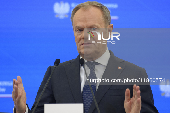 Polish Prime Minister Donald Tusk gestures as he speaks during a press conference with French President Emmanuel Macron after talks in Warsa...