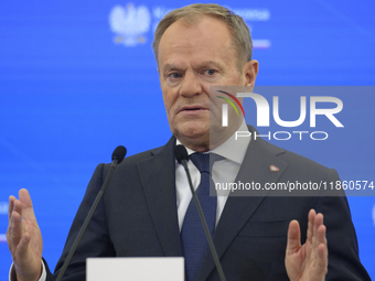 Polish Prime Minister Donald Tusk gestures as he speaks during a press conference with French President Emmanuel Macron after talks in Warsa...