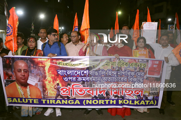 An activist of the Bengali Hindu Protection Association stands with a poster featuring a portrait of Bangladesh's interim leader Muhammad Yu...