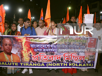 An activist of the Bengali Hindu Protection Association stands with a poster featuring a portrait of Bangladesh's interim leader Muhammad Yu...