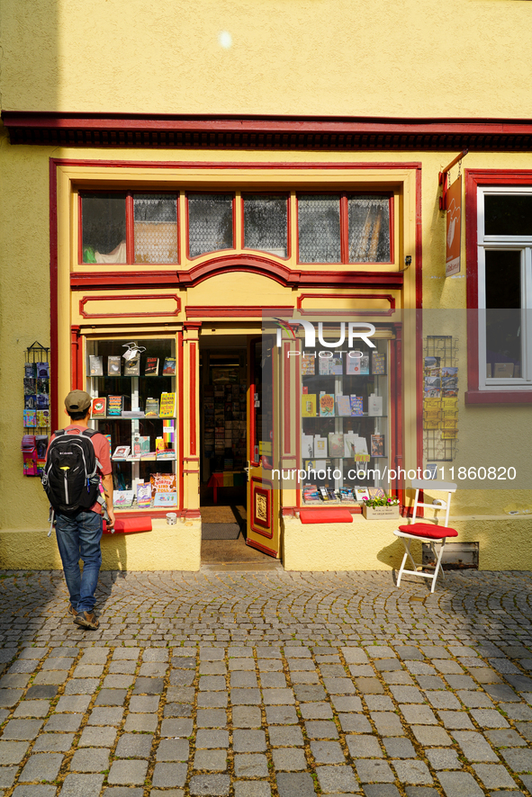 A young man stops to admire the display of books in the windows of Buchladen Die Zeitgenossen in Esslingen, Germany, on June 30, 2023. The b...