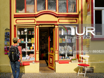 A young man stops to admire the display of books in the windows of Buchladen Die Zeitgenossen in Esslingen, Germany, on June 30, 2023. The b...