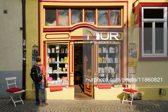 A young man stops to admire the display of books in the windows of Buchladen Die Zeitgenossen in Esslingen, Germany, on June 30, 2023. The b...