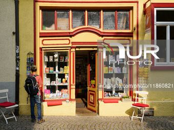 A young man stops to admire the display of books in the windows of Buchladen Die Zeitgenossen in Esslingen, Germany, on June 30, 2023. The b...