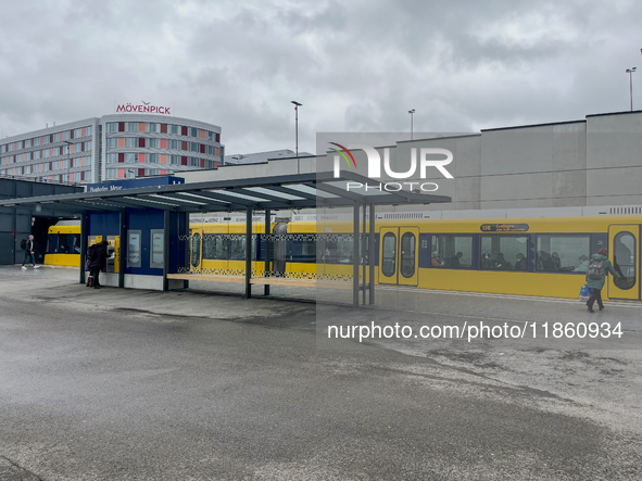 A yellow tram of the Stuttgart Stadtbahn serves passengers at Stuttgart Airport Messe Station in Stuttgart, Germany, on March 10, 2023. The...