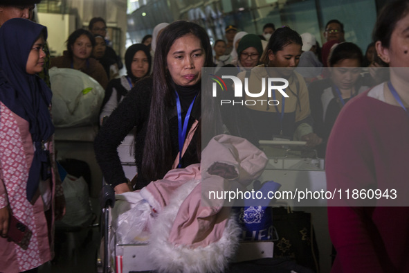 Indonesian citizens (WNI) walk out of the arrivals terminal shortly after arriving from Syria at Soekarno-Hatta Airport in Tangerang, Banten...