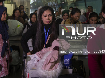 Indonesian citizens (WNI) walk out of the arrivals terminal shortly after arriving from Syria at Soekarno-Hatta Airport in Tangerang, Banten...